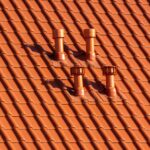 close up of chimneys on top of an orange roof